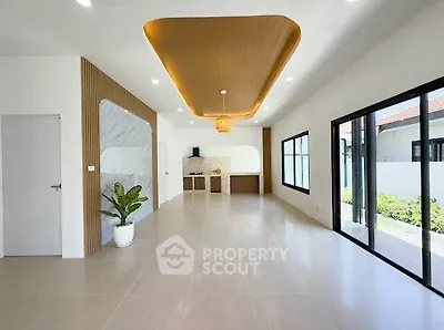 Spacious modern living room with elegant ceiling design and large windows for natural light.