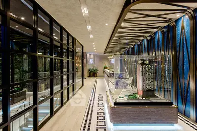 Luxurious modern building lobby with architectural model and stylish design elements.