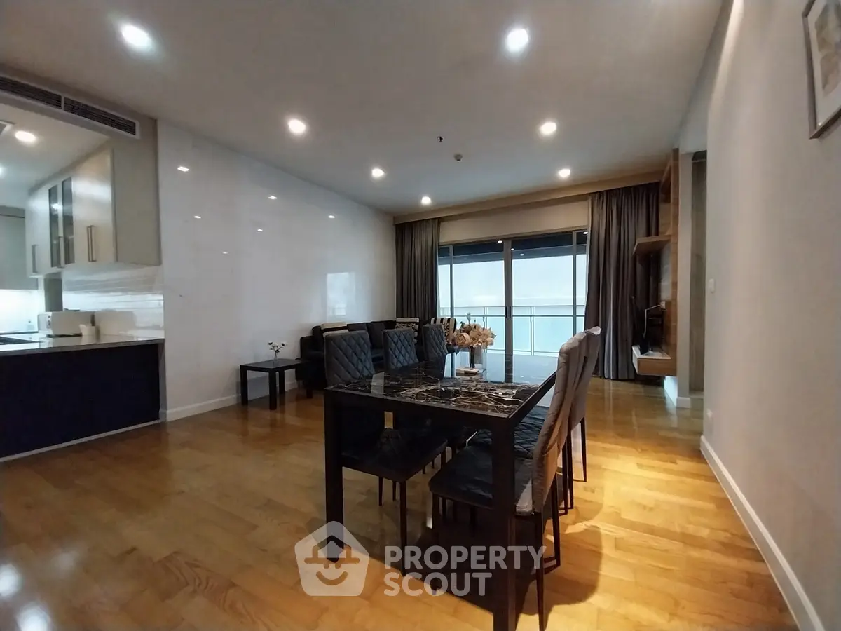 Spacious dining area with elegant wooden flooring and modern decor in a luxury apartment.