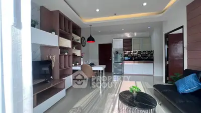 Modern living room with open kitchen, stylish furniture, and natural light