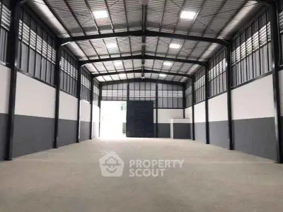 Spacious industrial warehouse with high ceilings and ample natural light.