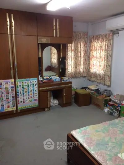 Cozy bedroom with ample storage and floral curtains, perfect for a comfortable living space.