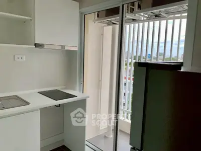 Modern kitchen with balcony view, featuring sleek appliances and open layout for urban living.