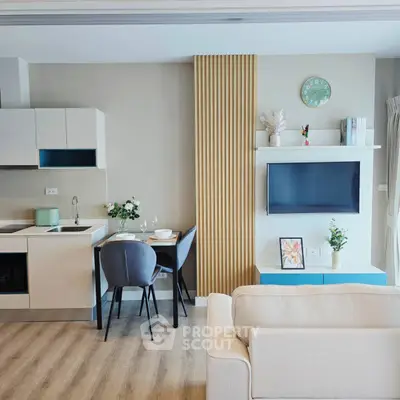 Modern open-plan living room with stylish decor and compact kitchen area.