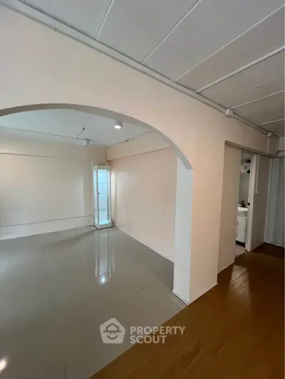 Spacious interior with glossy flooring and archway, ideal for modern living.