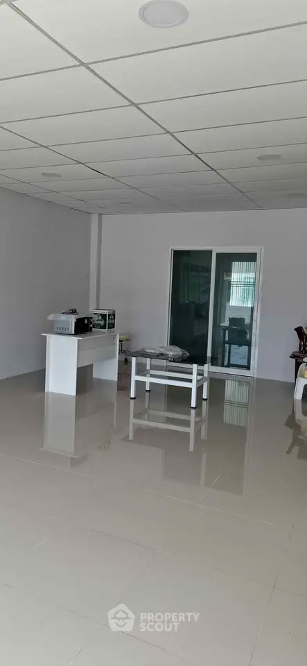 Spacious modern living area with sleek tiled flooring and minimalist design, perfect for customization.