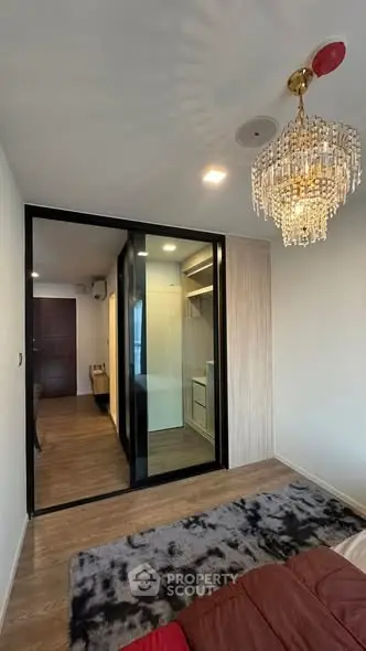Modern bedroom with elegant chandelier and glass sliding doors