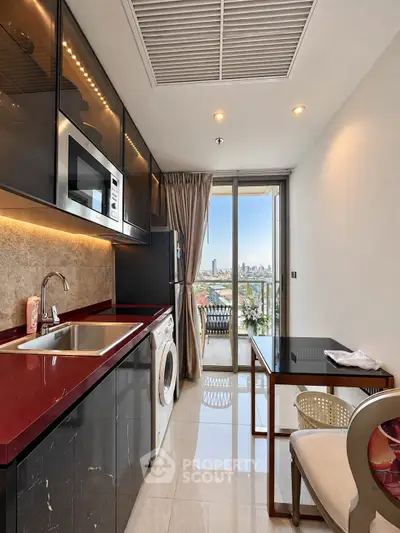 Modern kitchen with sleek black cabinets, red countertop, and city view from balcony.
