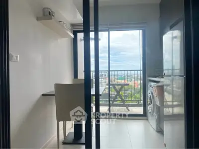 Modern kitchen with balcony view, featuring sleek appliances and dining area.