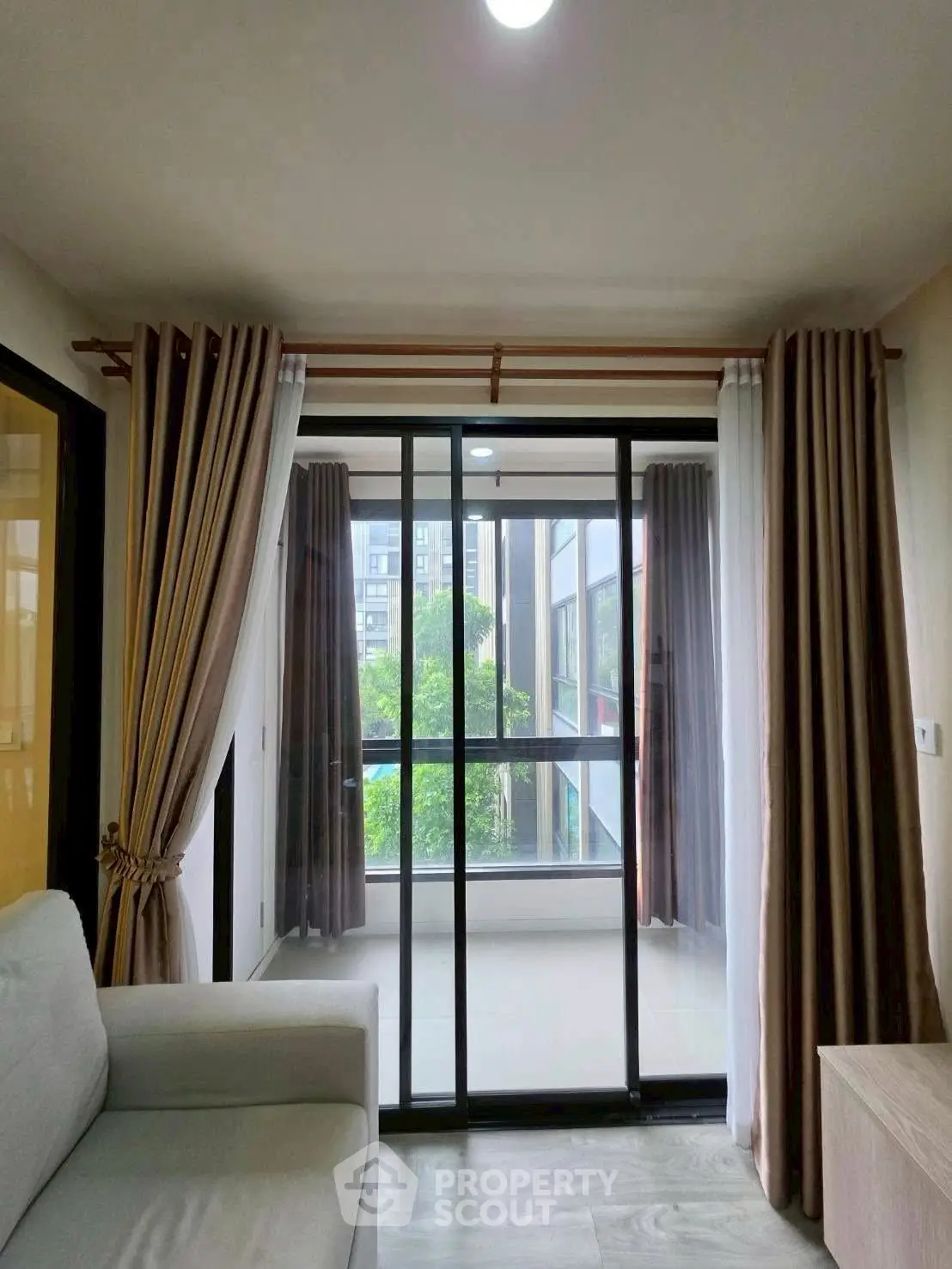 Modern living room with large glass doors leading to a balcony, offering a bright and airy atmosphere.