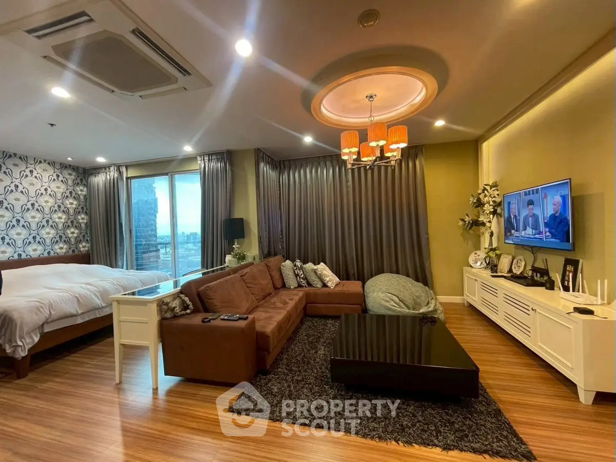 Luxurious living room with elegant decor and cozy bedroom area, featuring modern lighting and stylish furniture.