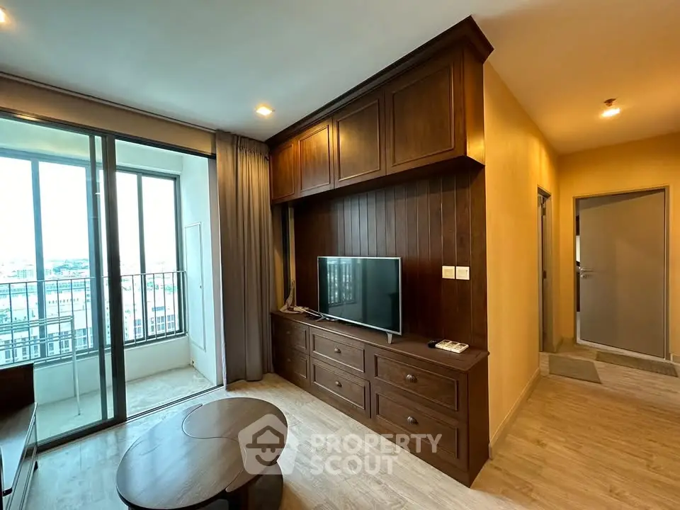 Charming living room with wooden cabinetry and balcony view in modern apartment.