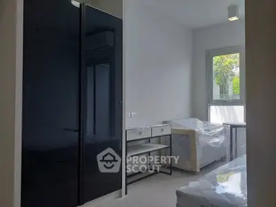 Modern bedroom with sleek black wardrobe and natural light