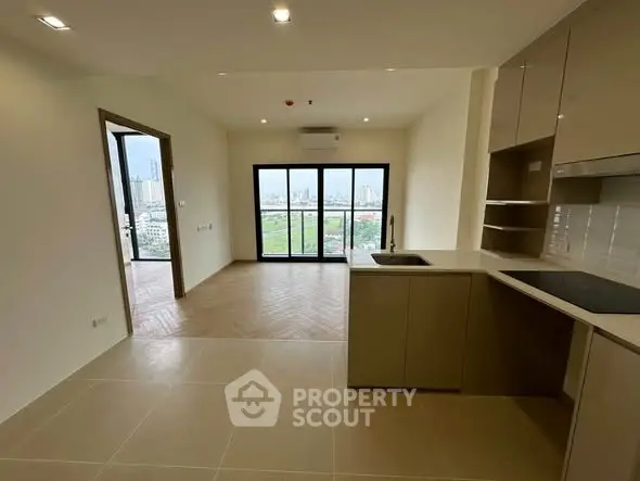 Modern open-plan kitchen and living room with city view and balcony access.