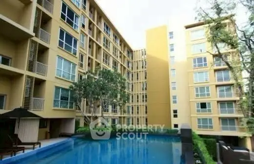 Modern apartment building with pool and lush greenery, perfect for urban living.
