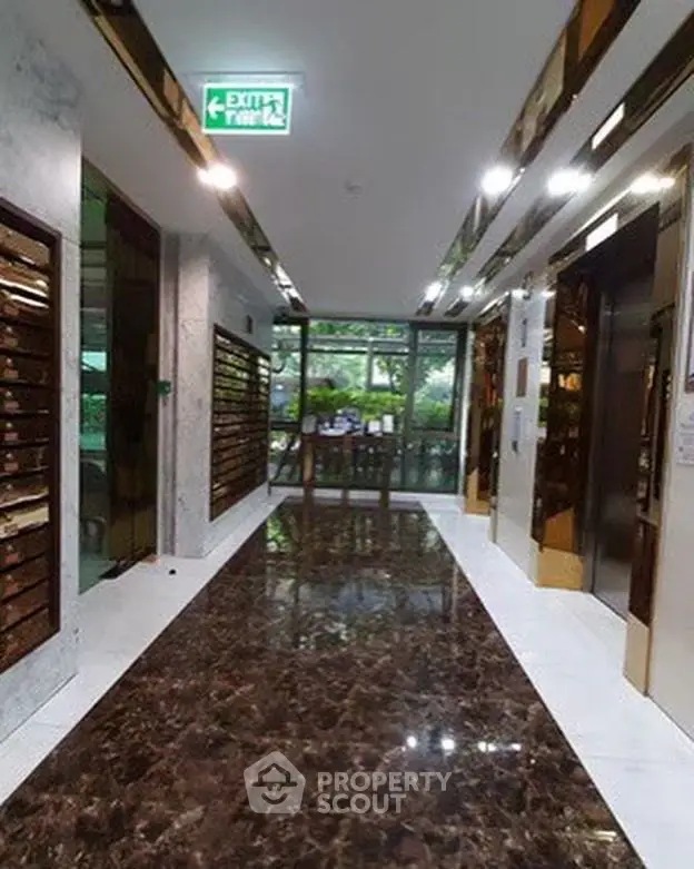 Luxurious building entrance with marble floors and modern mailboxes.