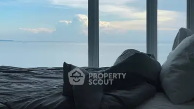 Luxurious bedroom with stunning ocean view through large windows.