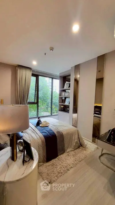 Luxurious bedroom with modern decor and large window overlooking greenery.