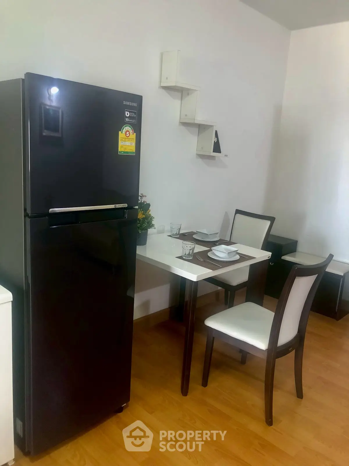 Cozy dining area with modern fridge and elegant table setting in a stylish apartment.