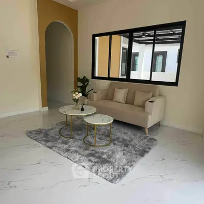 Modern living room with stylish sofa and coffee tables on a plush rug.