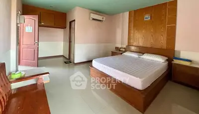 Spacious bedroom with wooden accents and modern air conditioning unit.