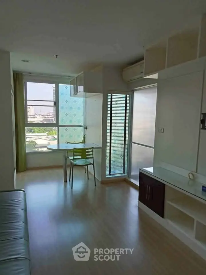 Bright and airy living room with large windows and modern furnishings in a city apartment.