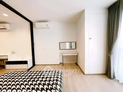 Modern bedroom with stylish decor and natural light, featuring a sleek desk and air conditioning.