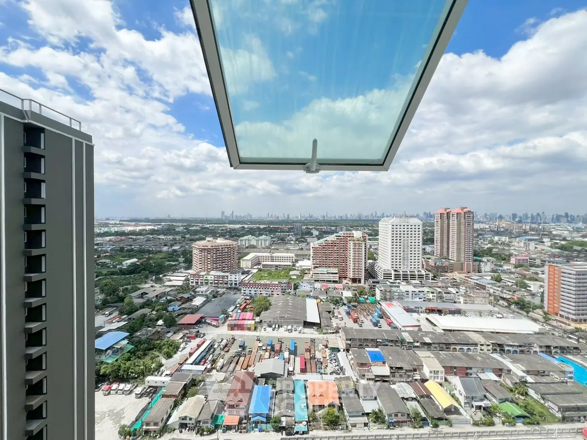 Stunning urban view from high-rise balcony with cityscape and blue sky.