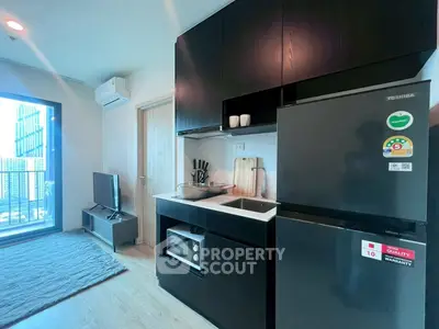 Modern kitchen with sleek black cabinets and appliances in a stylish apartment