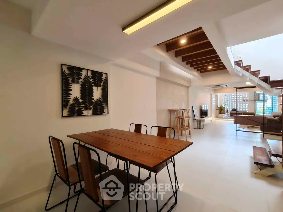 Modern open-plan living and dining area with stylish wooden furniture and contemporary decor.