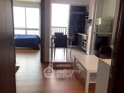 Modern apartment interior with open layout, featuring a cozy bedroom and compact kitchen area.