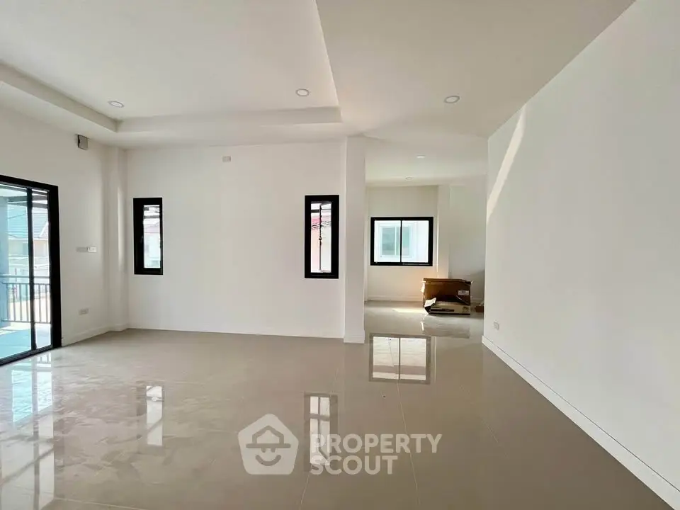 Spacious modern living room with large windows and glossy tiled floors