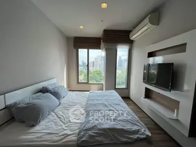 Modern bedroom with city view, featuring sleek design and large windows for natural light.