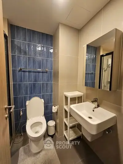 Modern bathroom with blue tiled wall and sleek fixtures