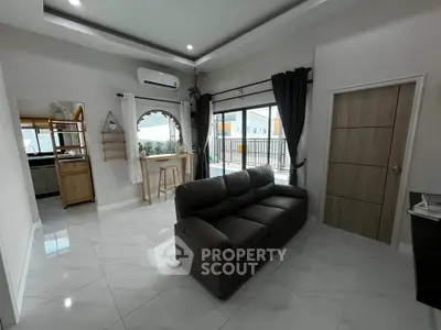 Modern living room with sleek sofa and large windows offering natural light