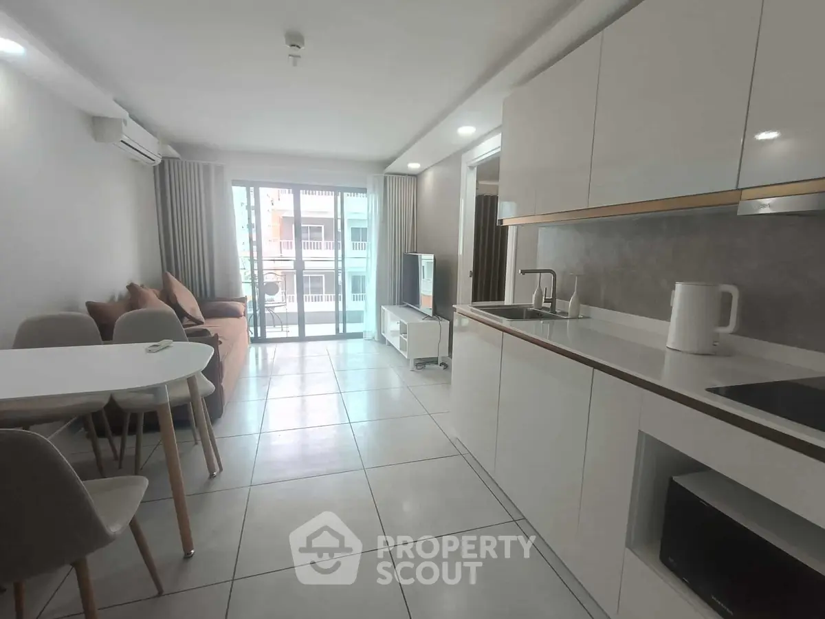 Modern open-plan living room and kitchen with sleek design and natural light.