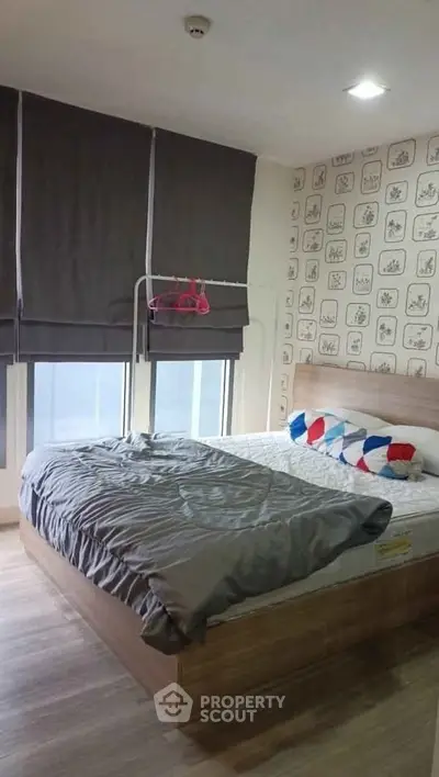 Cozy bedroom with modern decor and large windows in a stylish apartment.