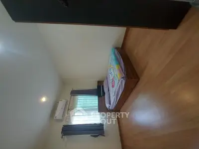 Cozy bedroom with wooden flooring and natural light