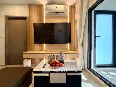 Modern living room with sleek TV setup and stylish decor, featuring a cozy ambiance and natural light.