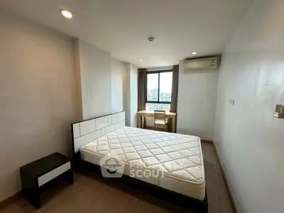 Spacious bedroom with city view, modern furnishings, and natural light.