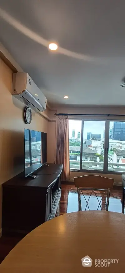 Spacious living room with city view and modern amenities in high-rise apartment.