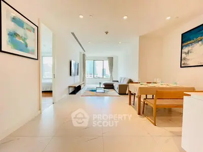 Spacious modern living room with dining area and large windows offering city views.