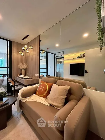 Modern living room with stylish decor and open layout, featuring a cozy sofa and elegant lighting.