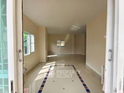 Spacious unfurnished living room with tiled flooring and ample natural light.