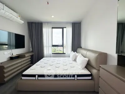Modern bedroom with large window and stylish furniture, offering a comfortable and inviting atmosphere.