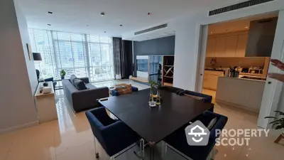 Modern open-plan living and dining area with city view and sleek kitchen design.