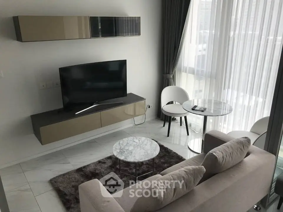 Modern living room with sleek furniture and large windows offering natural light.