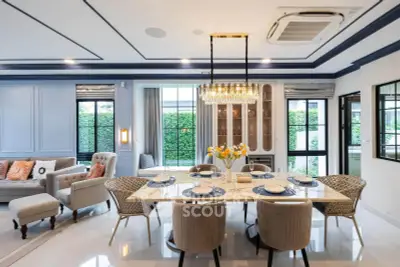 Luxurious open-plan living and dining area with elegant decor and garden view.