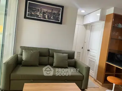 Modern living room with green sofa and cityscape artwork, featuring a cozy and stylish interior design.