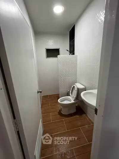 Compact bathroom with modern fixtures and tiled flooring, ideal for efficient space utilization.